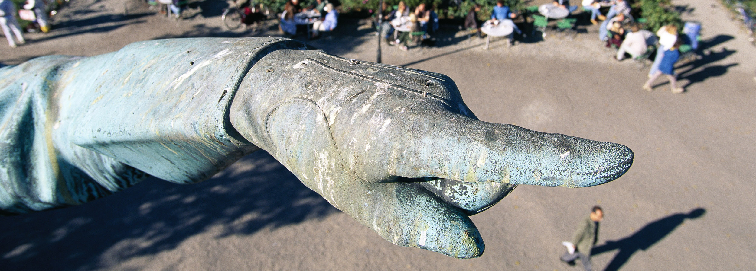 Närbild på hand på en staty som pekar mot ett håll