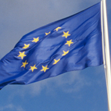 En flaggstång med eu-flaggan mot blå himmel 