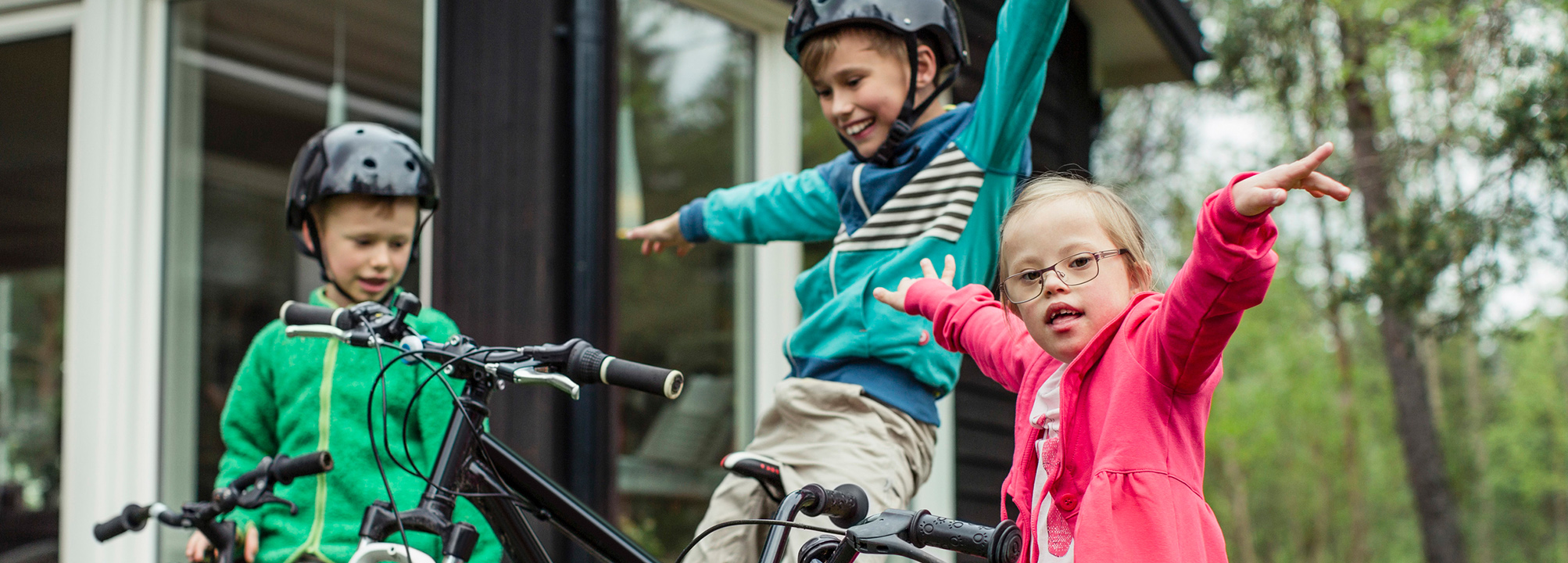 Tre barn leker med cyklar