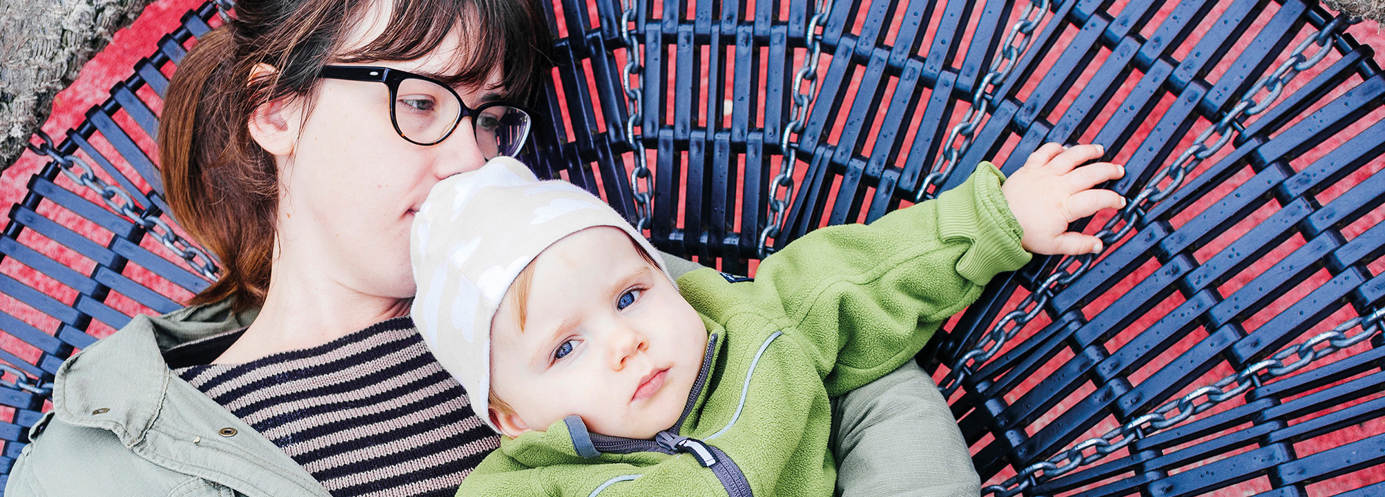 En mamma med sin baby i en gunga. 