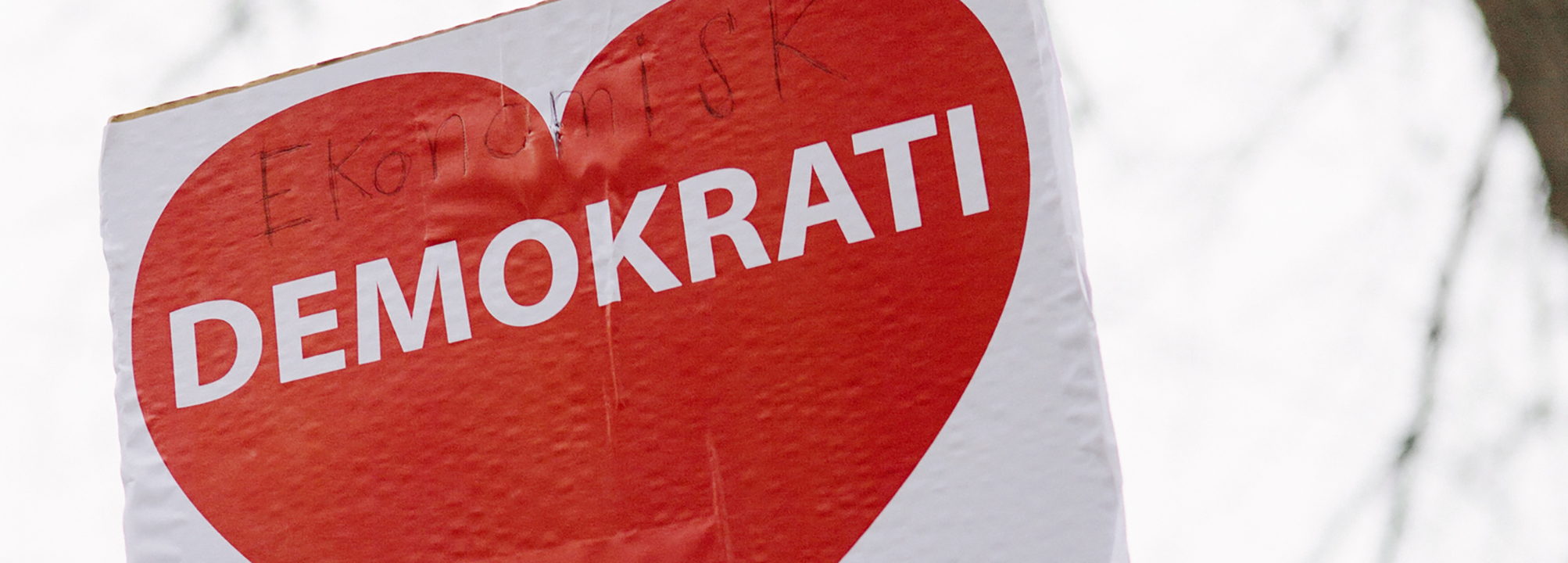  Ett plakat med ett rött hjärta på med texten demokrati