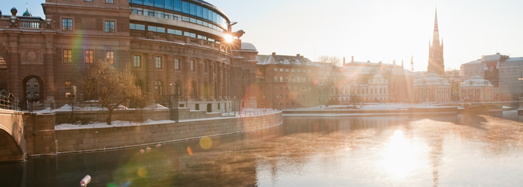 Stadsbild med riksdagshuset i motljus.