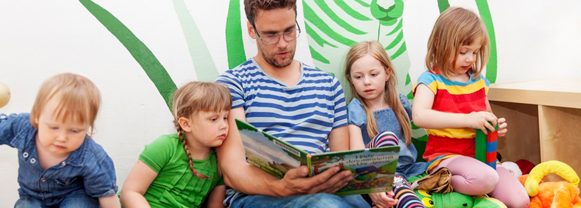 En man läser för en grupp småbarn. 