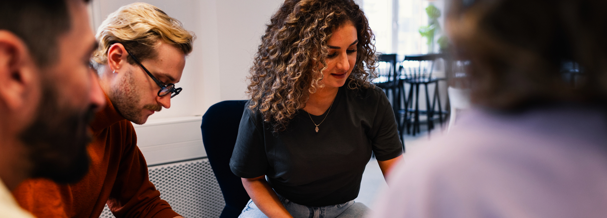 Fyra kollegor sitter i en kontorsmiljö och ser ut att hjärnstorma tillsammans.