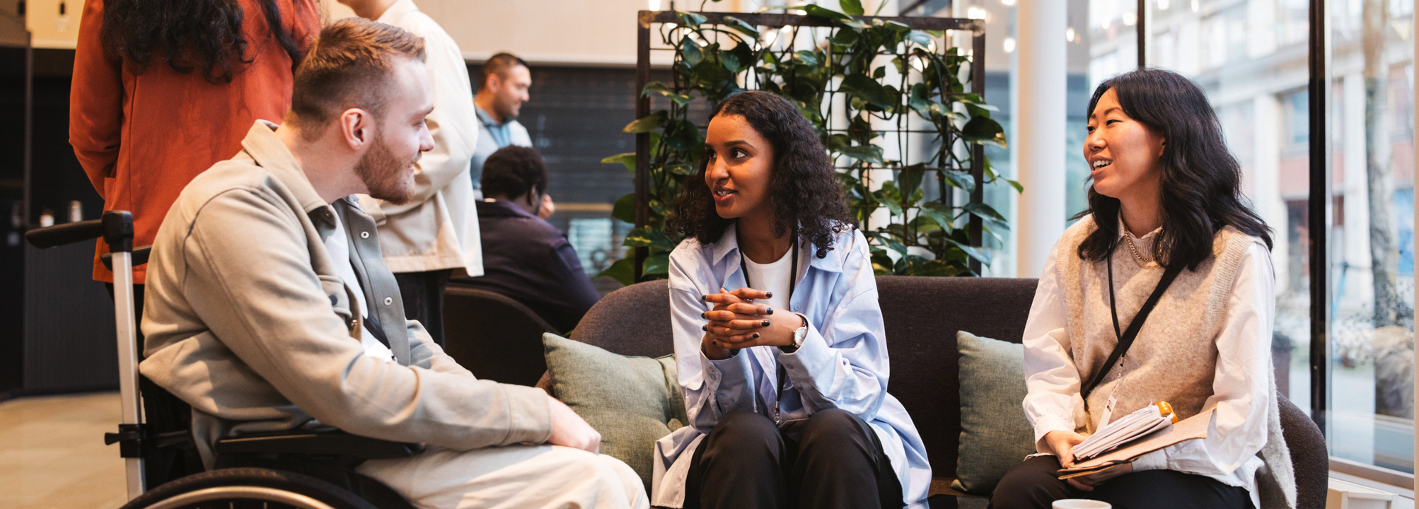 En grupp människor som sitter i en öppen yta på ett kontor.