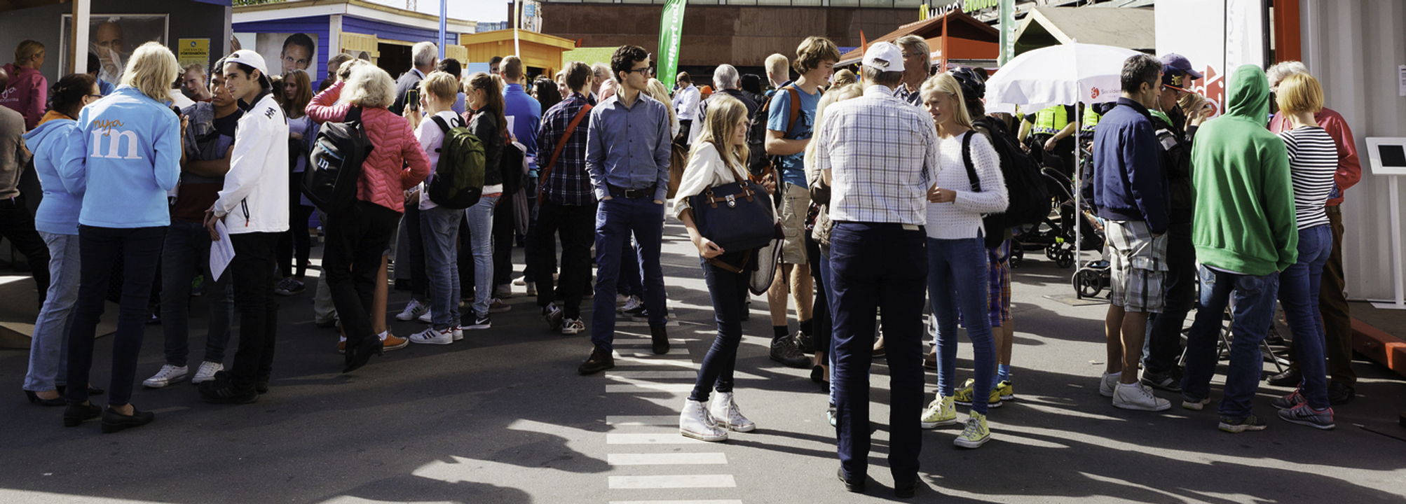 Stor samling människor vid valstugor i centrala Stockholm.