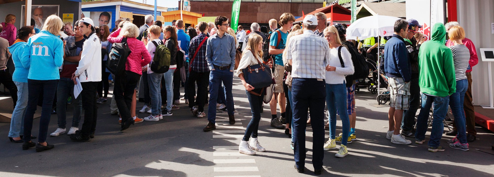 Stor samling människor vid valstugor i centrala Stockholm.