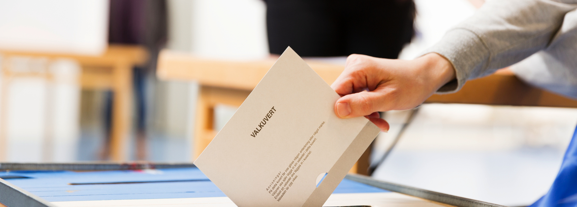 En person lägger sin röst i en vallokal